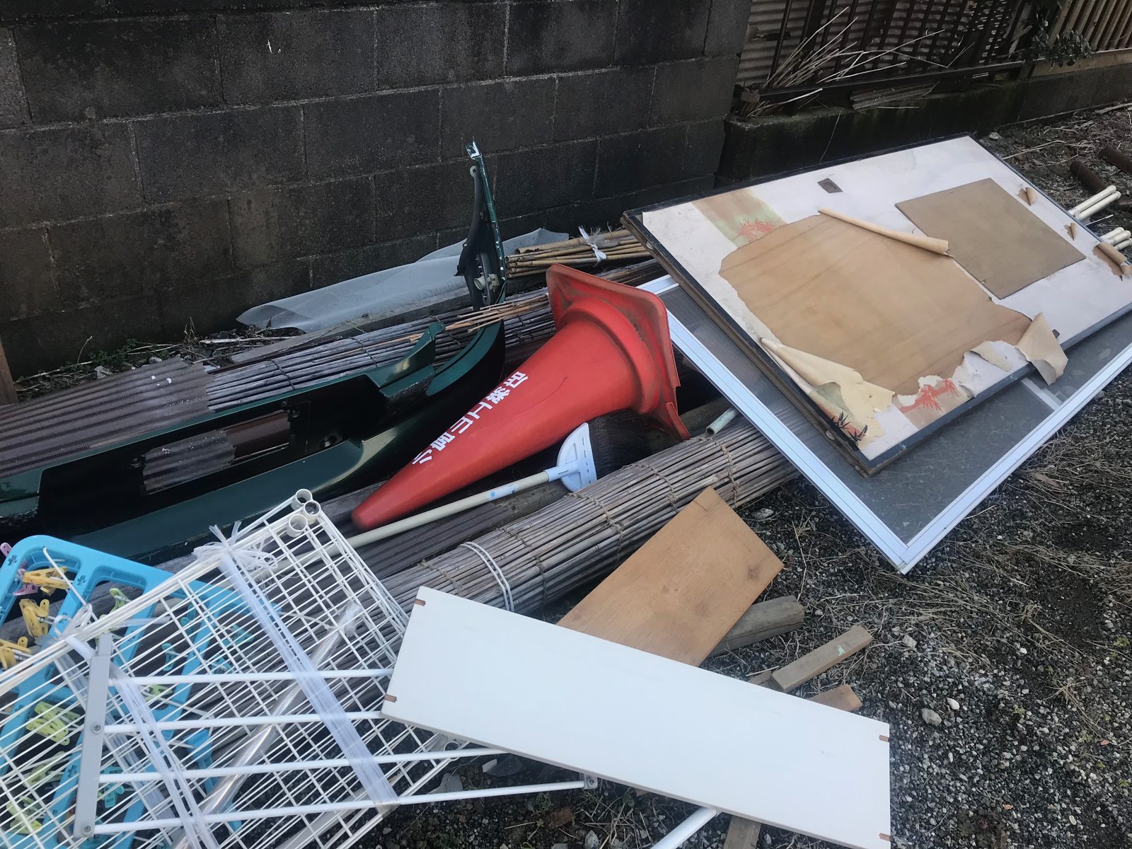 厚木市上落合の倉庫から運び出したカラーコーンやよしず、ワイヤーの棚、板材を塀沿いに並べた様子