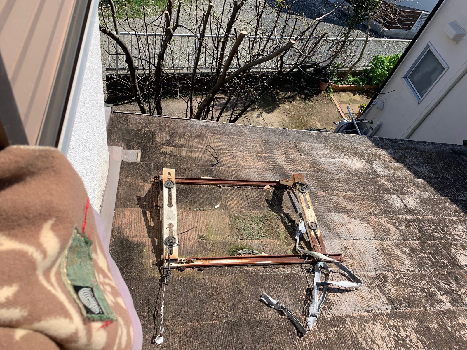 厚木市荻野で窓から見た屋根の上。室外機を載せる金属の架台と配線が写っている