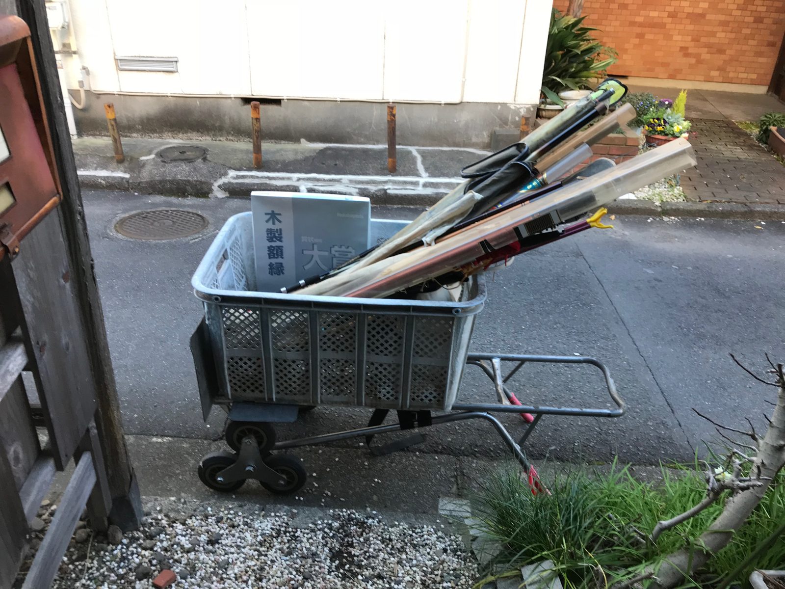 厚木市中町でかごに入れた釣竿40本の束を三輪の台車に載せた様子